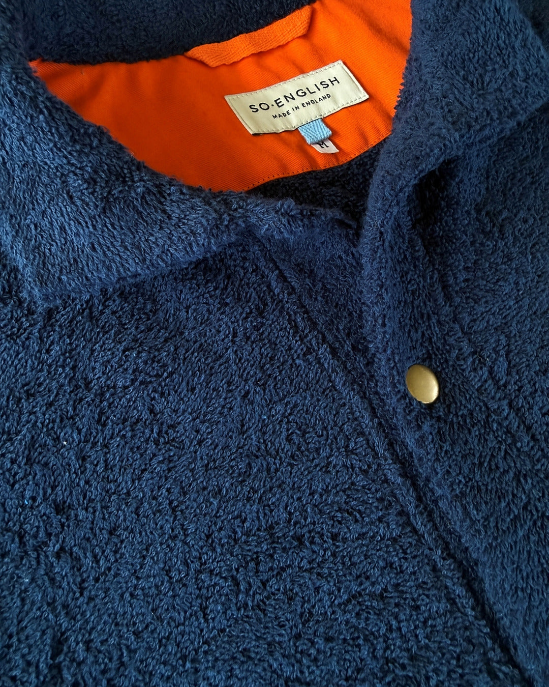 Navy Bond polo shirt by So English, close-up of the shirt's fabric and collar detail, made in the UK.