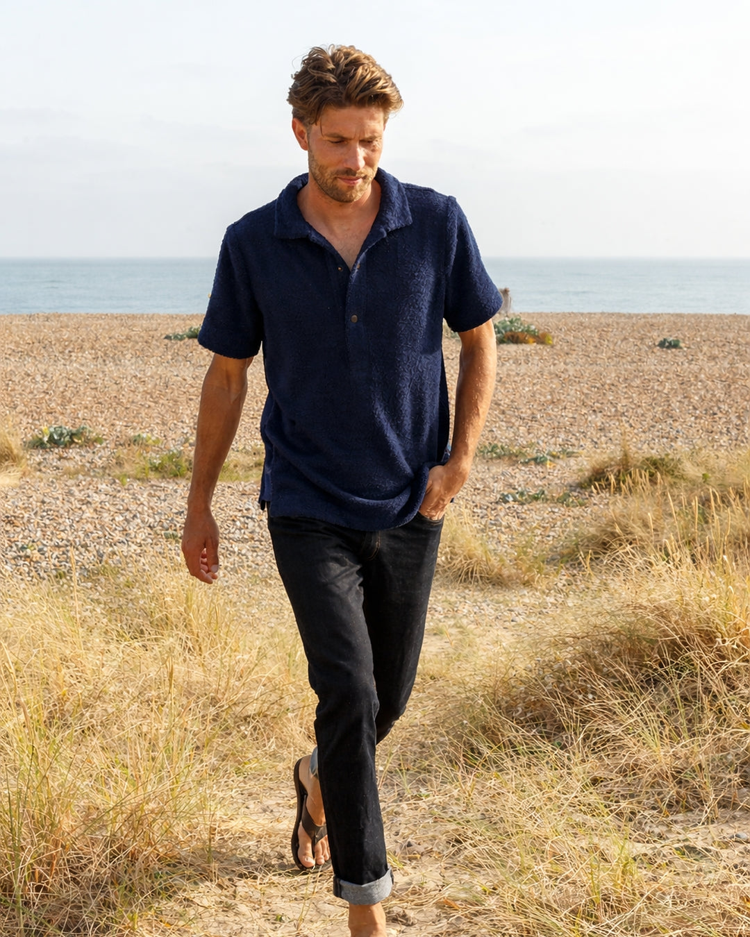 Navy Bond polo shirt from So English, made in the UK, displayed on a model showing the casual fit and classic collar detail.