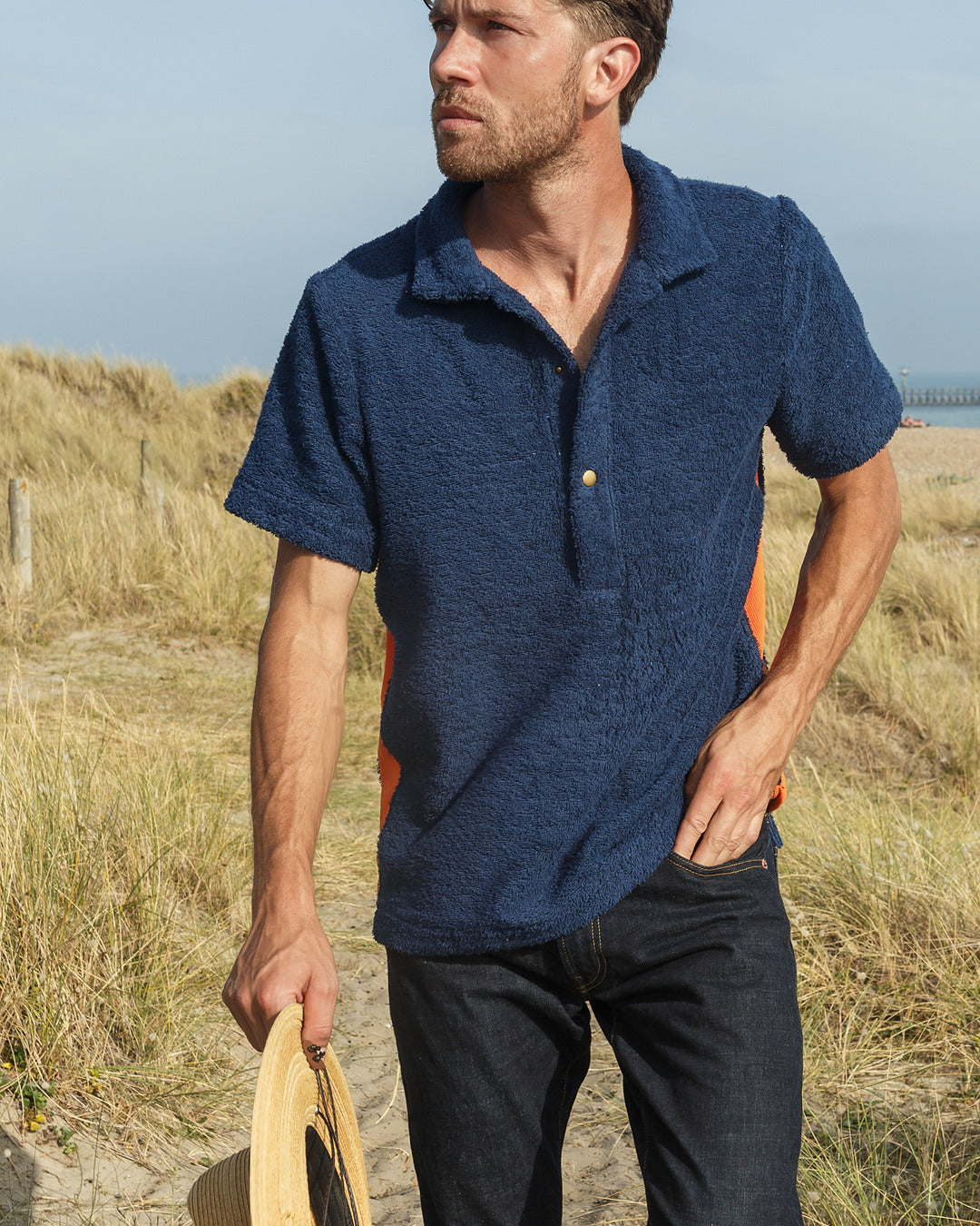 Navy and orange Bond polo shirt by So English, featuring a classic design and breathable fabric, displayed on a plain background.
