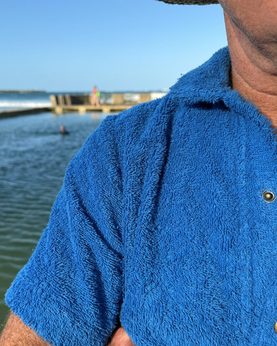 So English Bond polo shirt in Brighton Blue, featuring detailed close-up of the branded logo on the fabric.