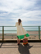 Model pictured from the back wearing Ramona almond + green long towelling robe at the beach