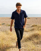 Navy Bond polo shirt by So English, made in the UK, displayed on a model showcasing casual beachwear style.