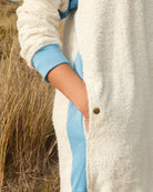 Long ecru and sky blue hoodie by So English featuring a relaxed fit and front pocket, perfect for casual beachwear.