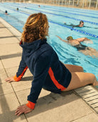 Navy and orange So English Hampstead hoodie displayed in a casual beachwear setting, made in the UK.