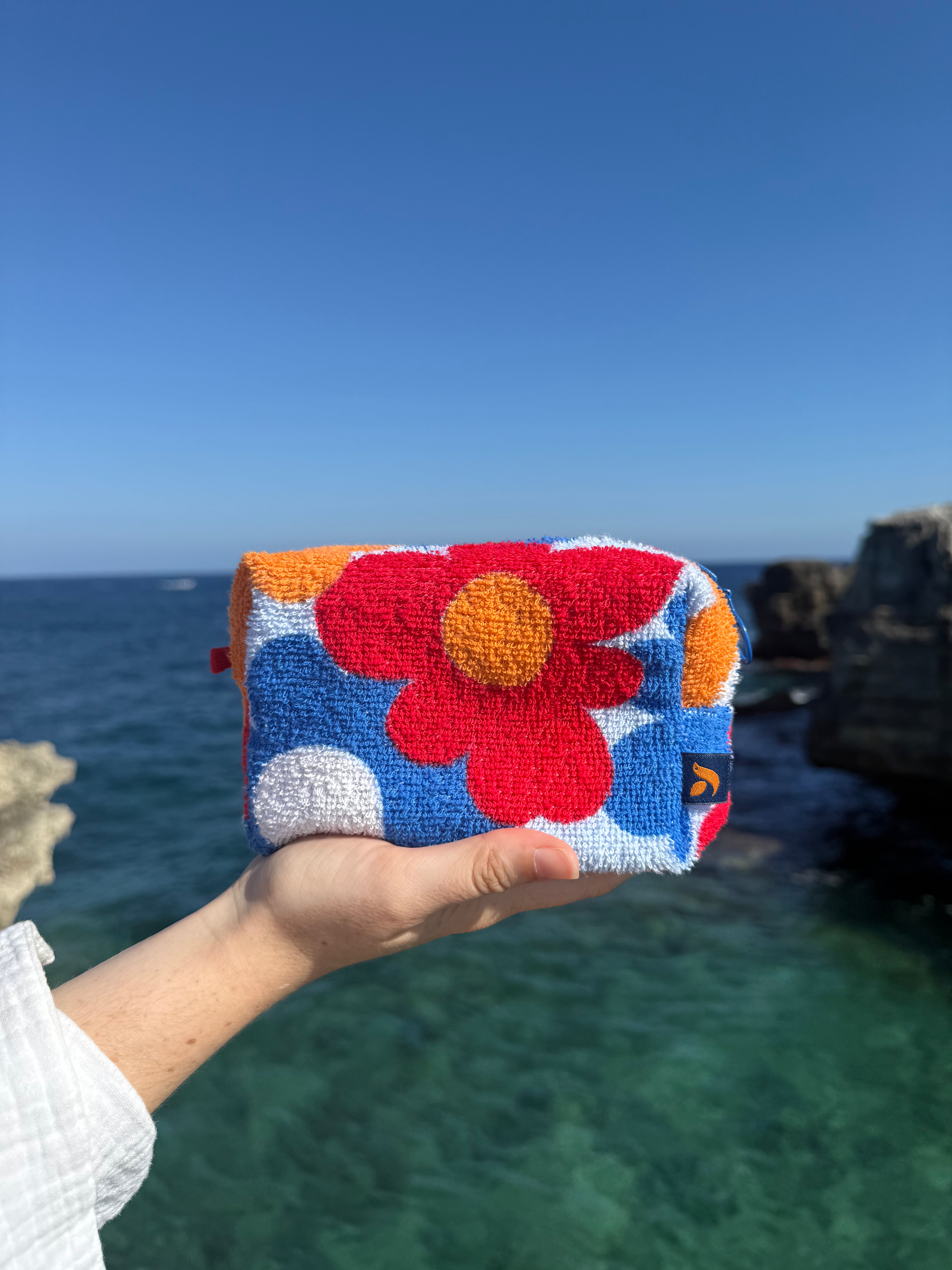 So English beachwear pochette bag made in the UK, stylish and compact accessory with natural fabric and elegant design.