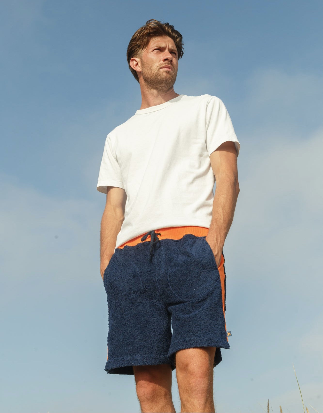 Navy and orange bear-themed men's shorts by So English, featuring a casual beachwear design made in the UK.