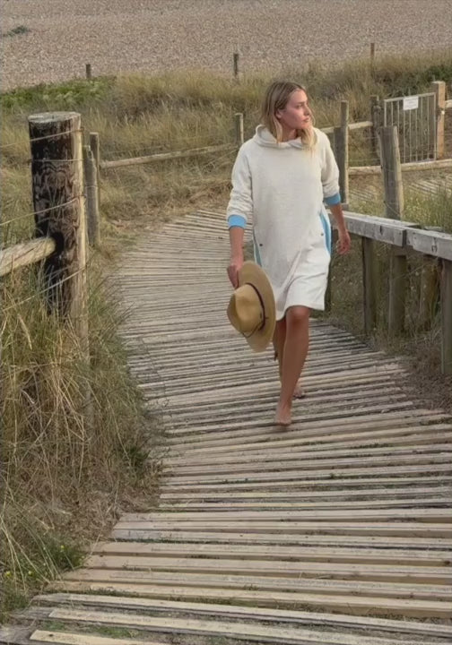 Video of a woman wearing the Bude terry towelling long hoodie in Ecru and Sky Blue by So English — Italian cotton, handmade in the UK.
